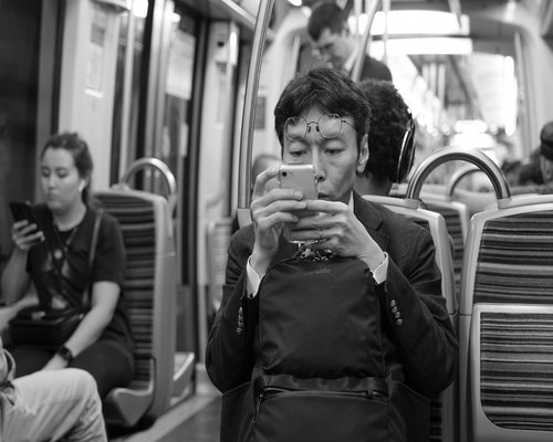 Person commuting on public transit using a smartphone at proper eye level